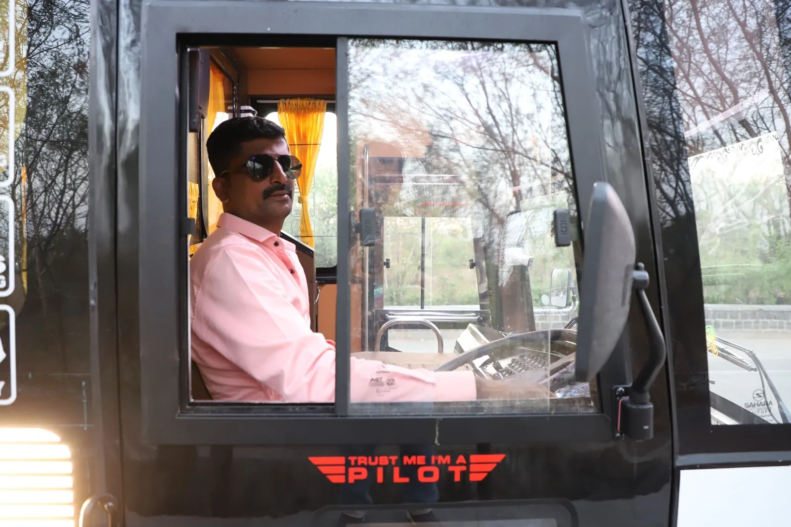 Professional bus driver seated with hand on the steering wheel